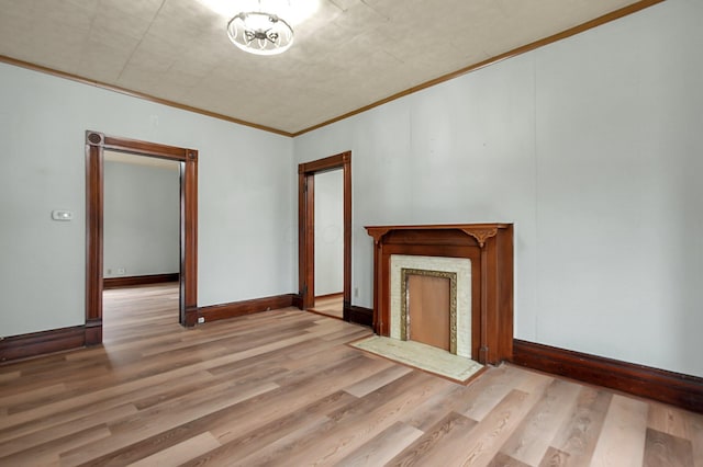 unfurnished living room with crown molding, a notable chandelier, and light wood-type flooring