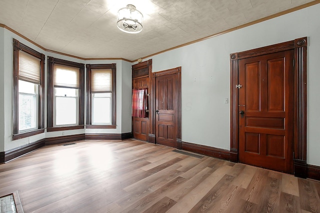 interior space with crown molding and light hardwood / wood-style flooring