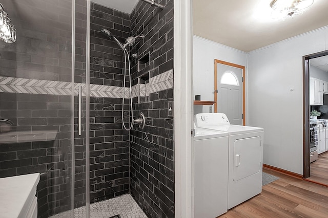 interior space with an enclosed shower, vanity, hardwood / wood-style flooring, and ornamental molding