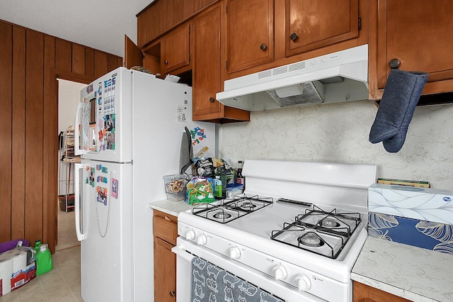 kitchen featuring light tile patterned flooring, white appliances, and decorative backsplash