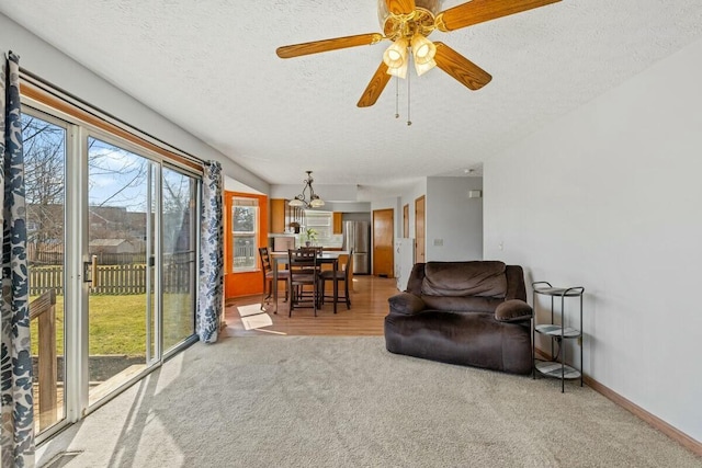 interior space with a ceiling fan, carpet, a textured ceiling, and baseboards