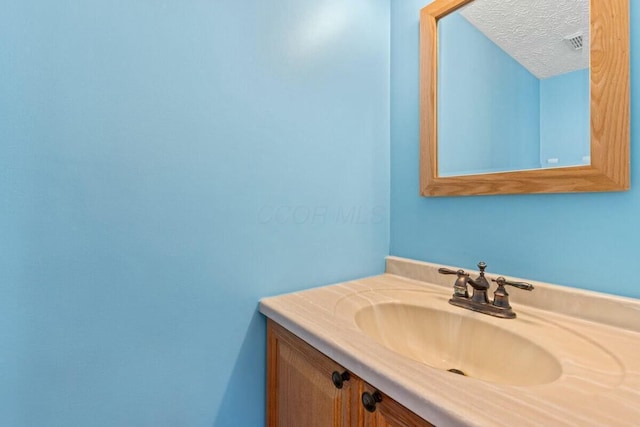 bathroom with visible vents, a textured ceiling, and vanity