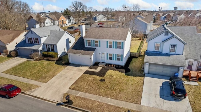 view of front of property featuring a residential view, a chimney, and concrete driveway