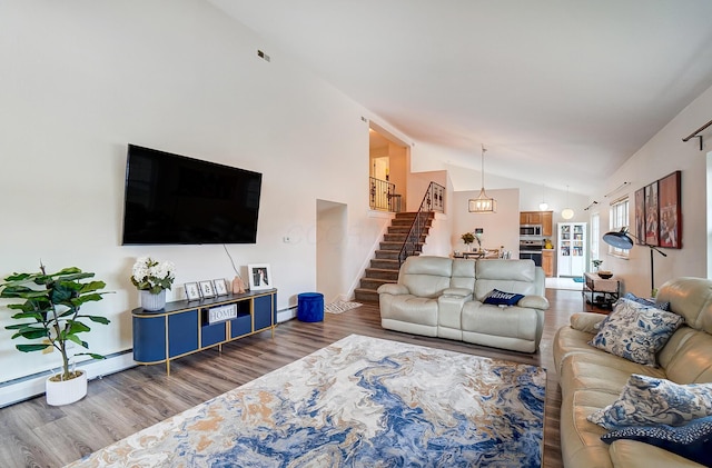 living room featuring baseboard heating, vaulted ceiling, and hardwood / wood-style floors