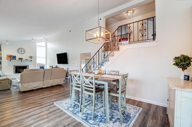 dining room featuring hardwood / wood-style flooring, high vaulted ceiling, and an inviting chandelier