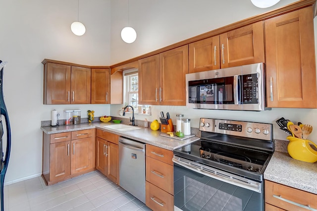 kitchen with sink, hanging light fixtures, a towering ceiling, stainless steel appliances, and light tile patterned flooring