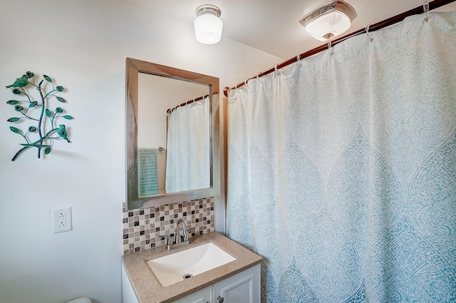 bathroom with tasteful backsplash and vanity