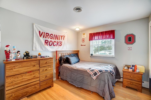 bedroom featuring light hardwood / wood-style flooring and a baseboard radiator