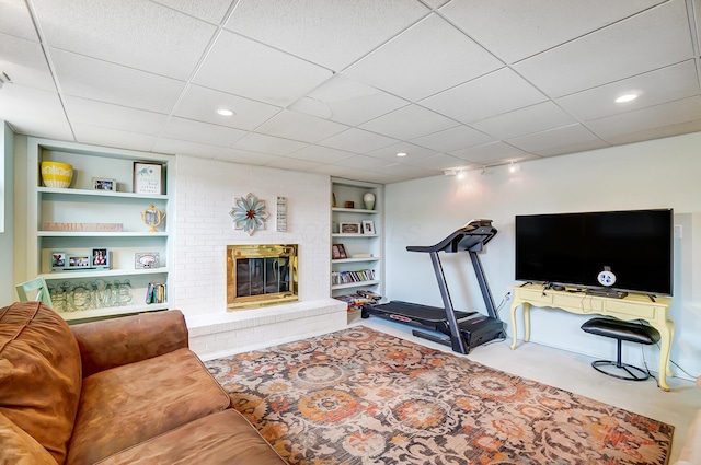 workout area with a fireplace and built in shelves