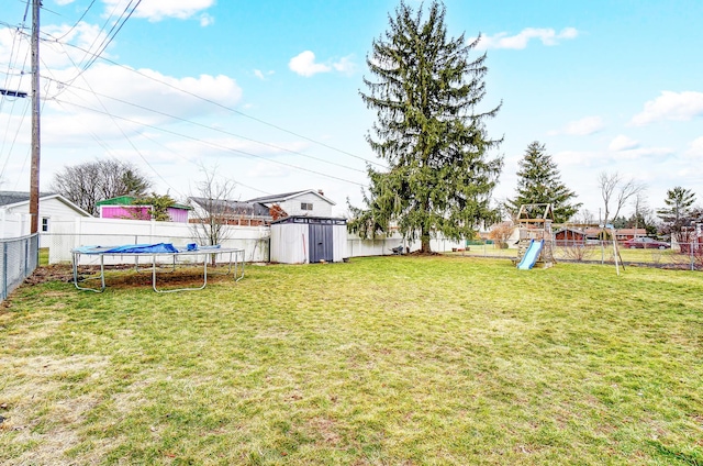 view of yard with a playground, a trampoline, and a storage unit