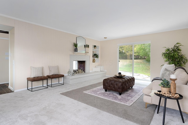 living room featuring ornamental molding, a brick fireplace, and carpet flooring