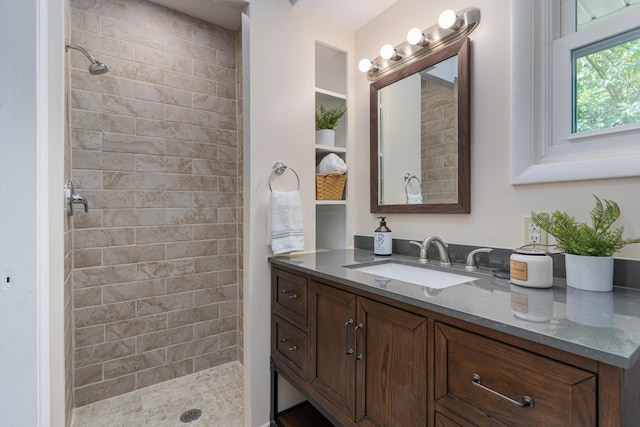 bathroom with vanity and tiled shower