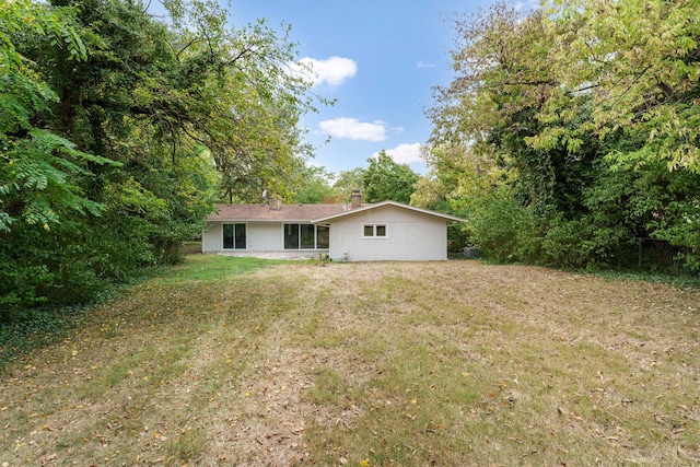 rear view of house featuring a lawn