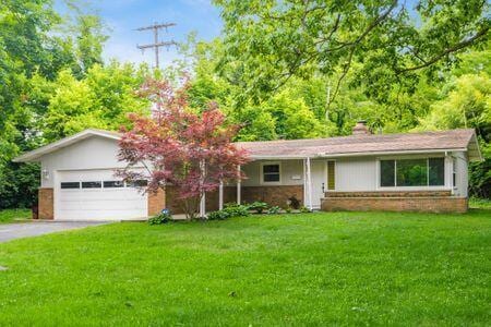 single story home featuring a garage and a front lawn