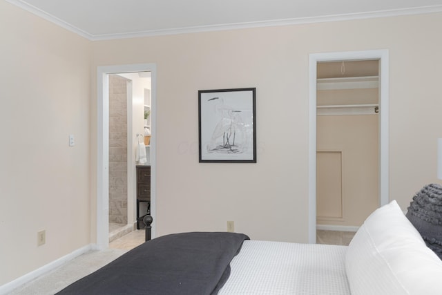 carpeted bedroom featuring ornamental molding, a walk in closet, and ensuite bath