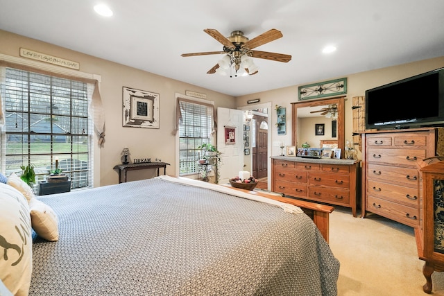 bedroom featuring multiple windows, light colored carpet, and ceiling fan