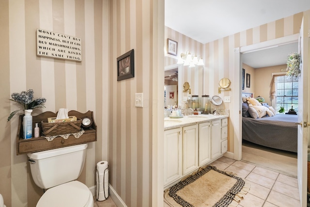 bathroom with tile patterned flooring, vanity, and toilet