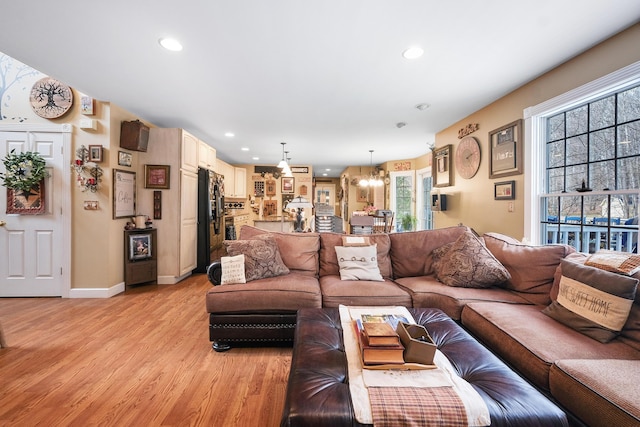 living room featuring a notable chandelier and light hardwood / wood-style flooring