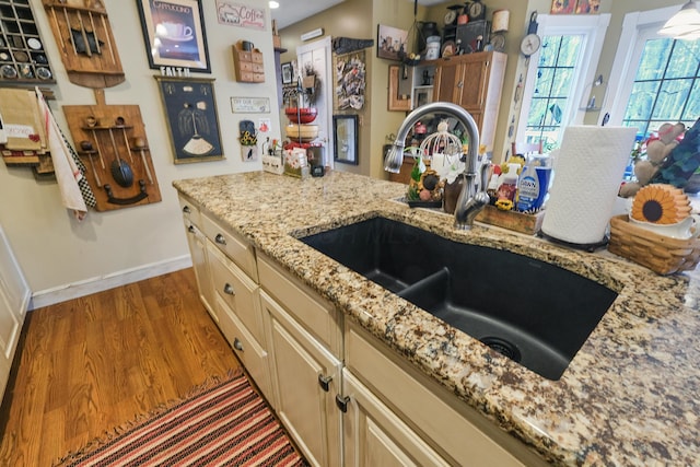 kitchen featuring dark wood-type flooring, sink, and light stone counters