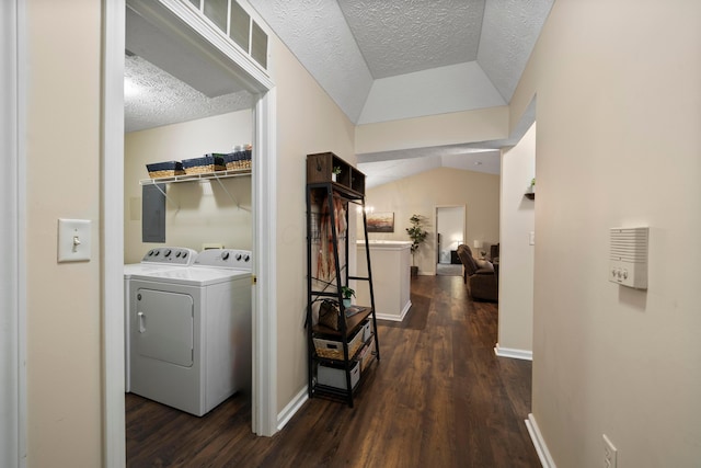 hallway featuring dark wood finished floors, washer and dryer, a textured ceiling, and baseboards