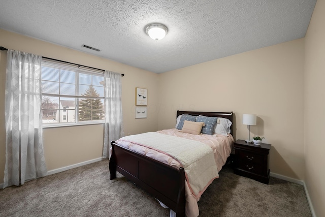 bedroom featuring visible vents, baseboards, carpet, and a textured ceiling