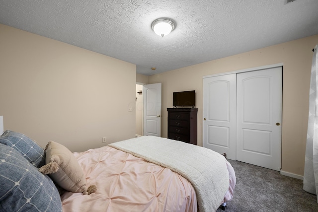 bedroom with a closet, carpet, and a textured ceiling