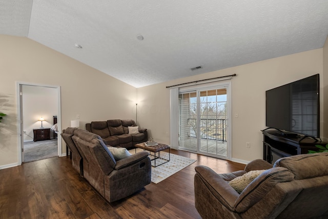 living area with visible vents, a textured ceiling, dark wood-style floors, and vaulted ceiling