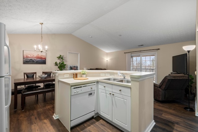 kitchen featuring open floor plan, lofted ceiling, dark wood-style floors, white appliances, and a sink