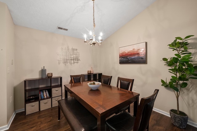 dining space featuring visible vents, baseboards, lofted ceiling, an inviting chandelier, and wood finished floors