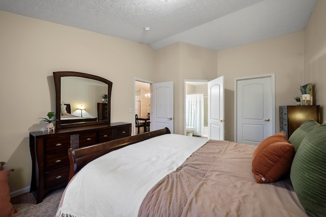 carpeted bedroom featuring connected bathroom, baseboards, a textured ceiling, and vaulted ceiling