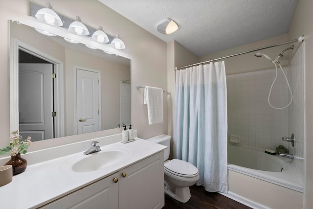 full bath with vanity, wood finished floors, shower / bathtub combination with curtain, a textured ceiling, and toilet