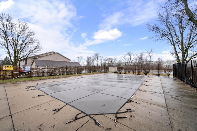 community pool with a patio and fence