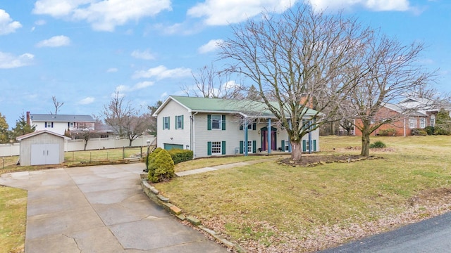 view of front of home with a garage, a front yard, and a storage shed