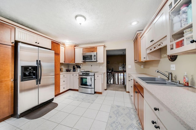 kitchen with white cabinetry, appliances with stainless steel finishes, sink, and a textured ceiling