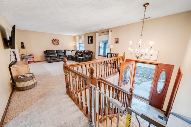 interior space with carpet floors, a textured ceiling, and a chandelier