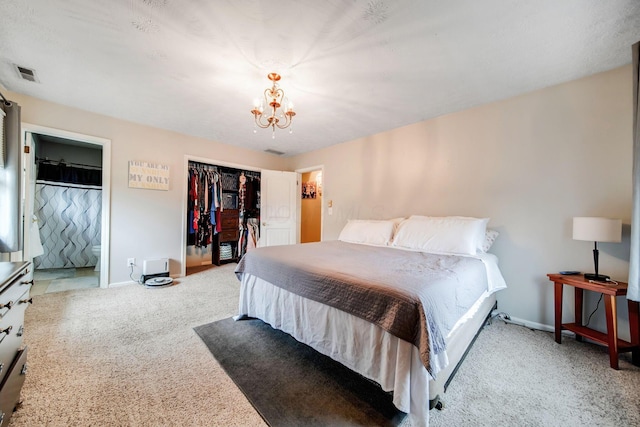bedroom featuring connected bathroom, light colored carpet, a notable chandelier, and a closet