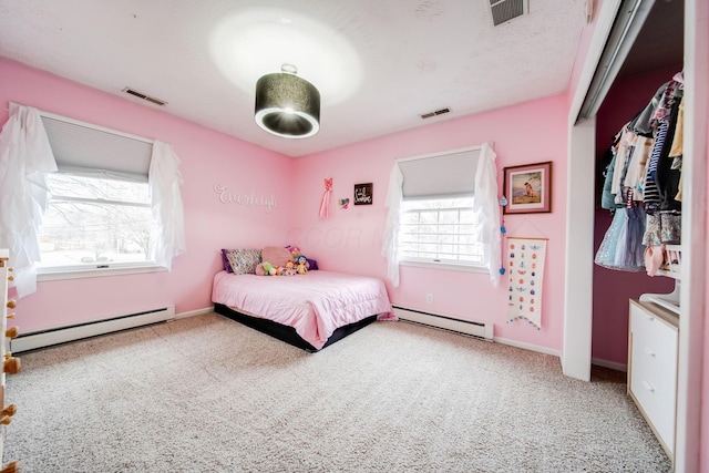 bedroom with baseboard heating and carpet