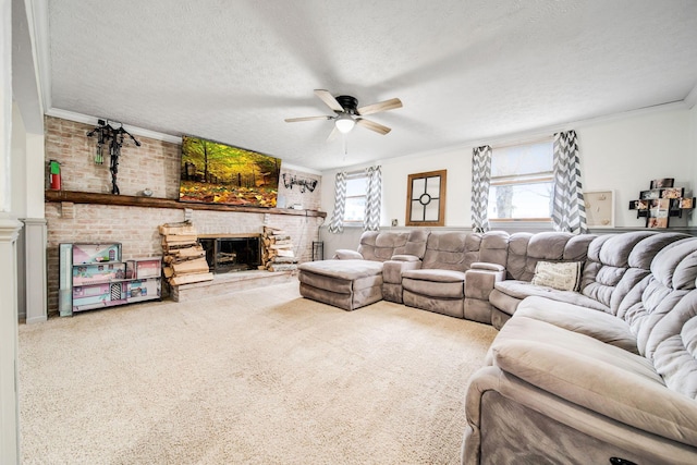 living room with ceiling fan, carpet flooring, a fireplace, ornamental molding, and a textured ceiling