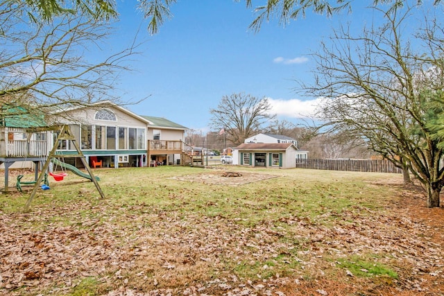 view of yard with an outdoor structure, a playground, and a sunroom