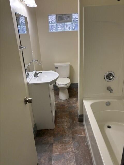 bathroom featuring washtub / shower combination, baseboards, vanity, and toilet