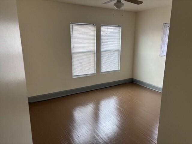 unfurnished room featuring ceiling fan, baseboards, and wood finished floors