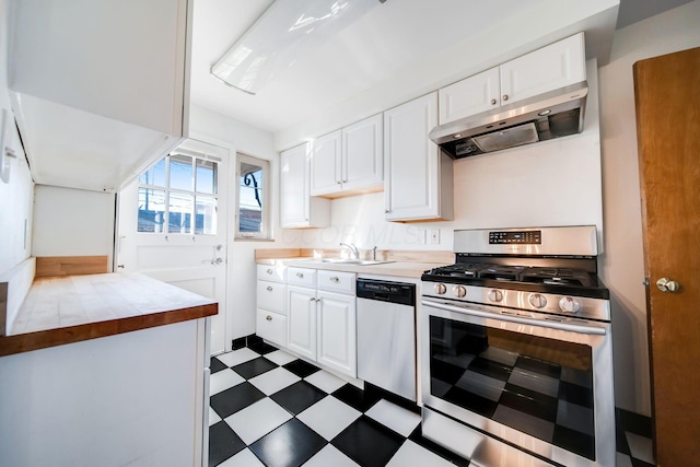 kitchen featuring white cabinetry, stainless steel appliances, range hood, and sink