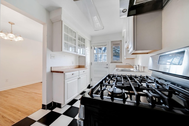 kitchen with sink, white cabinetry, an inviting chandelier, wooden counters, and pendant lighting