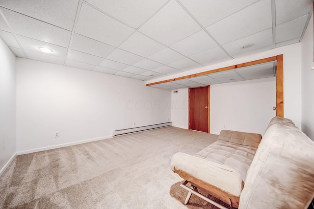 unfurnished room featuring a baseboard radiator, carpet, and a drop ceiling