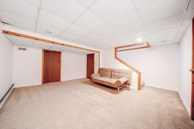 unfurnished room featuring a paneled ceiling, carpet flooring, and a baseboard heating unit