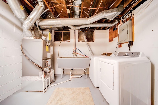 laundry room featuring heating unit, sink, electric panel, and washing machine and clothes dryer