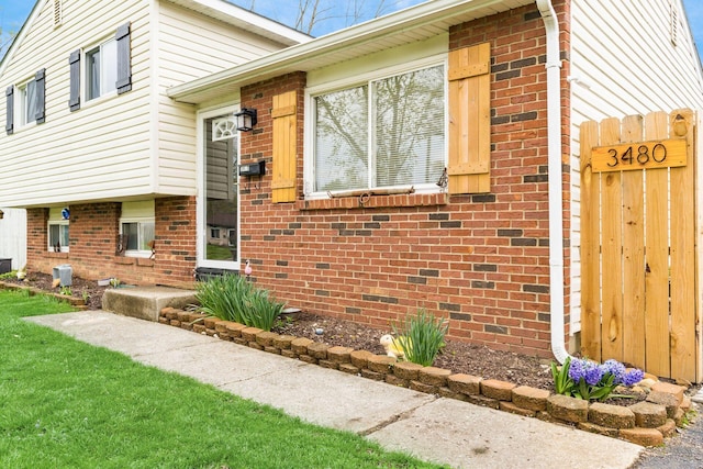 view of property exterior featuring a yard and brick siding