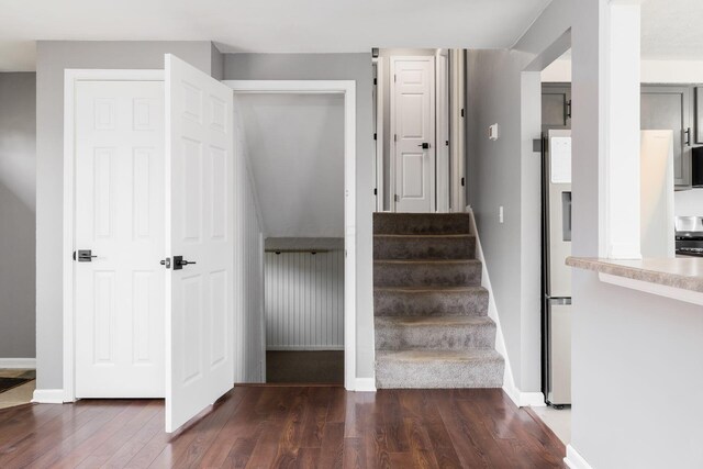 stairway featuring wood finished floors and baseboards
