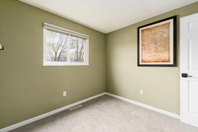 carpeted empty room with baseboards and visible vents