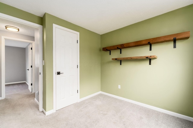 unfurnished bedroom featuring baseboards and light carpet